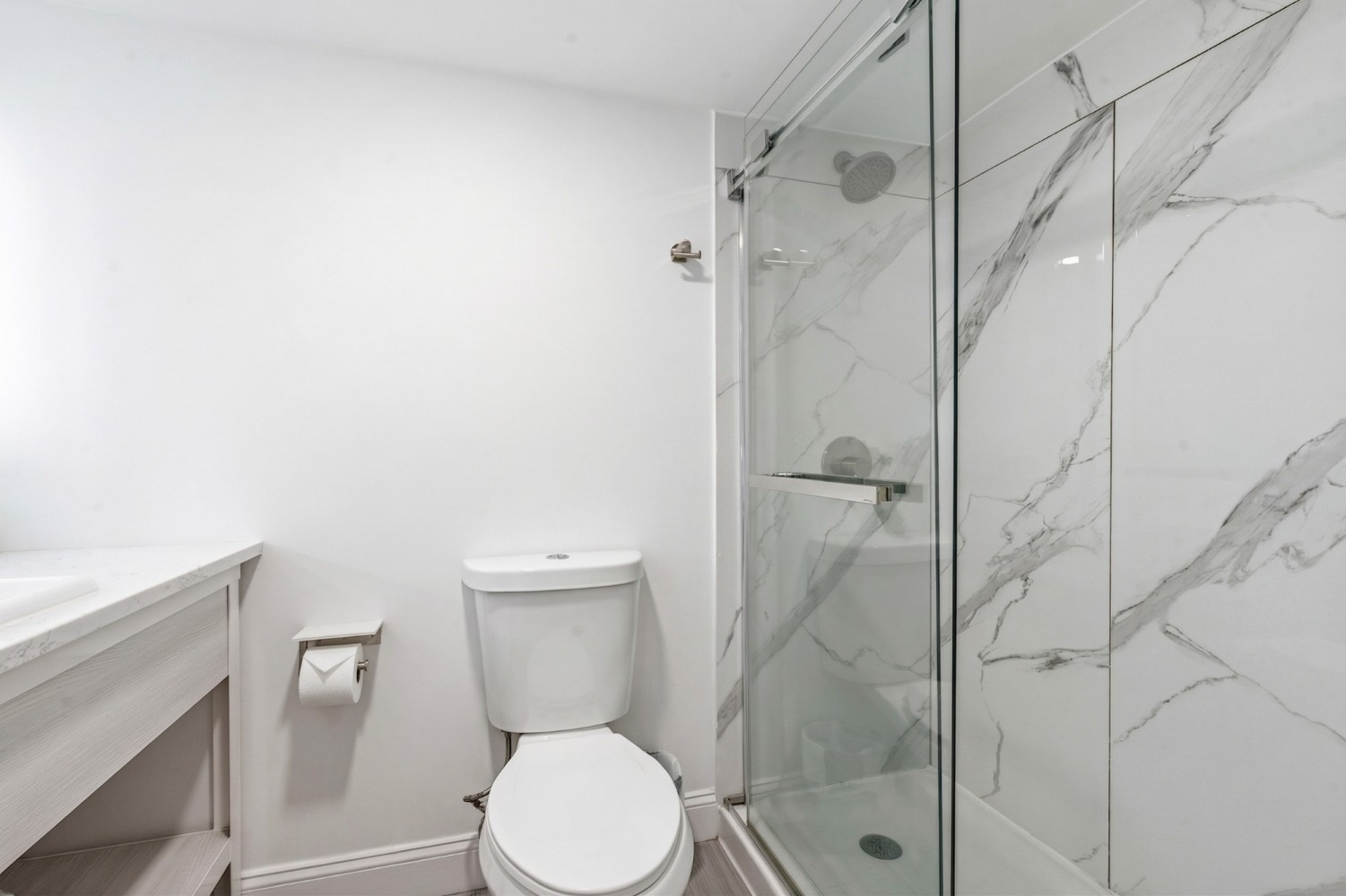 A standard bathroom with a toilet, shower, and sink