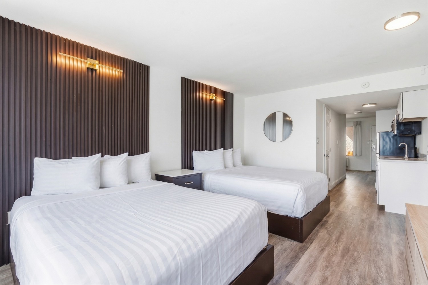 A suite with two beds and a kitchenette