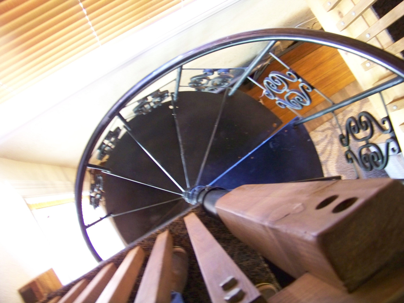 a spiral staircase with a metal railing and wooden steps