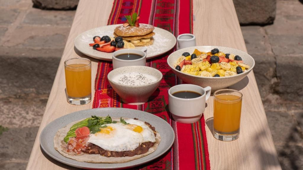 a breakfast spread on a wooden table with a red runner