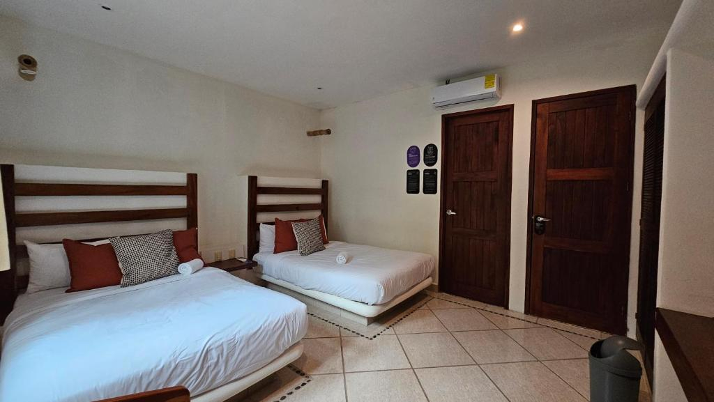A hotel room with two beds, a tiled floor, and wooden furniture.